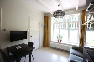 - un salon avec une table et une grande fenêtre dans l'établissement Recreatieappartement BoerdeRijlst - De Kamer, à Sint Nicolaasga