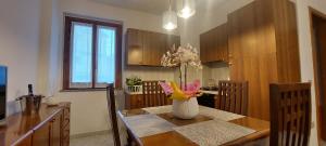 Sweet Home Simona في زامبروني: مطبخ مع طاولة عليها إناء من الزهور