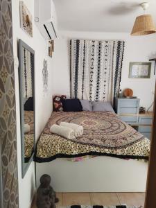 Dormitorio pequeño con cama y espejo en מקום קטן בשלווה a little peaceful place, en Arad
