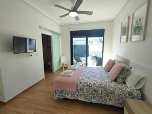 1 dormitorio con 1 cama y ventilador de techo en Villamolinos, villa con piscina privada. en San Pedro del Pinatar