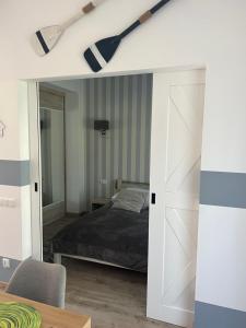 a bedroom with a bed and a sliding barn door at Słoneczny Port in Mikołajki