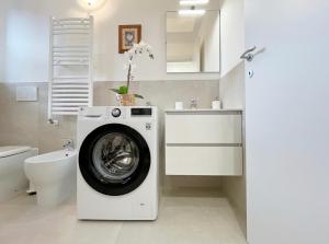 een wasruimte met een wasmachine in de badkamer bij Alloggio confortevole a Cadorago in Fino Mornasco