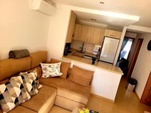 a living room with a couch and a kitchen at JARDIN 8 JOZMAR in Alhama de Murcia