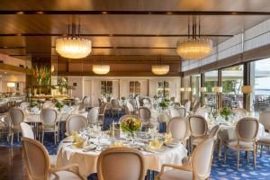a banquet hall with tables and chairs and chandeliers at Maritim Seehotel Timmendorfer Strand in Timmendorfer Strand