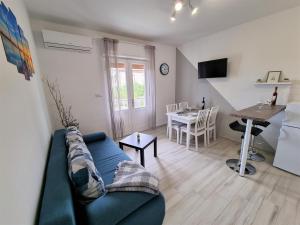 a living room with a blue couch and a table at Apartment House Kastelan in Banjol