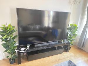 a large flat screen tv in a living room at Luxurious 1-bedroom apartment. Indoor Fireplace in South Norwood