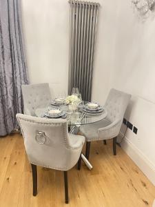 een eettafel met 2 stoelen en een glazen tafel en stoelen bij Luxurious 1-bedroom apartment. Indoor Fireplace in South Norwood