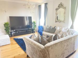 Luxurious 1-bedroom apartment. Indoor Fireplace في South Norwood: غرفة معيشة مع أريكة وتلفزيون بشاشة مسطحة