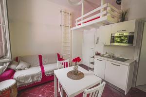 ein Wohnzimmer mit einem Sofa und einem Tisch sowie eine Küche in der Unterkunft LibertySuite Qcview2 in San Pellegrino Terme