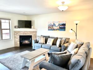 a living room with two couches and a fireplace at Perfect base Invermere 3bd townhouse mt views with garage in Invermere
