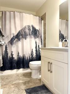 a bathroom with a mountain shower curtain with a toilet at Perfect base Invermere 3bd townhouse mt views with garage in Invermere
