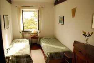 1 dormitorio con 2 camas y ventana en Villa Maia, en Neirone