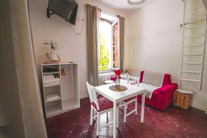 ein Wohnzimmer mit einem Tisch und einem roten Sofa in der Unterkunft LibertySuite Qcview2 in San Pellegrino Terme