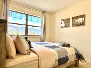 a bedroom with a bed in front of a window at Perfect base Invermere 3bd townhouse mt views with garage in Invermere