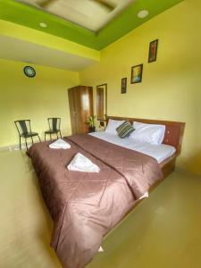 a large bed in a room with two chairs at Seashore Holiday Home in Revadanda