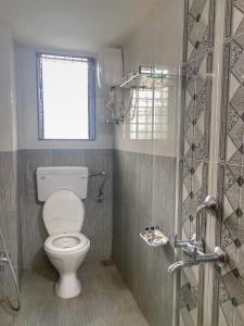 a bathroom with a toilet and a window and a shower at Seashore Holiday Home in Revadanda