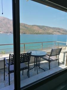 una mesa y sillas en un balcón con vistas al agua en Ocean views en Plataria