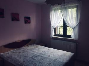 Sławatycze的住宿－Uroczysko Terebiski，一间卧室设有一张床和一个窗口