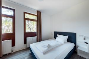 a bedroom with a large bed and two windows at Hotel Garni am Olgaeck in Stuttgart
