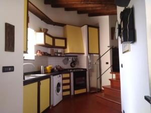 a kitchen with yellow and white cabinets and appliances at Villa Maia in Neirone