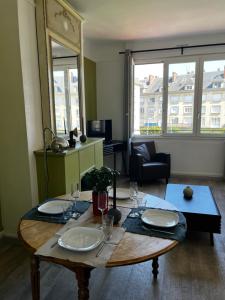 Sòlfar - Amiens (hypercentre) في أميان: غرفة معيشة مع طاولة مع صحون وكاسات