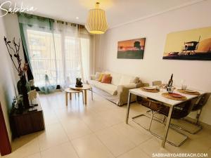 uma sala de estar com um sofá e uma mesa em Apartment Sabbia by Gabbeach Valencia em Valência