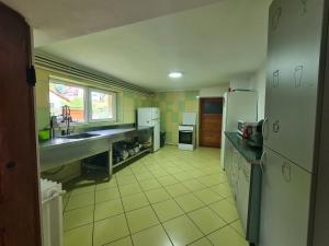 uma cozinha com electrodomésticos brancos e pisos em azulejo amarelo em CASA FLORESCU em Buşteni
