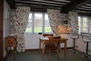 uma cozinha com mesa, cadeiras e janelas em Flat 1 - The Old Mill - Bowbridge Lock - Stroud em Stroud