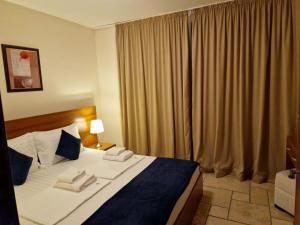 um quarto de hotel com uma cama grande e uma janela em HC Apartments Kaliakria em Topola