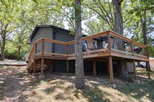 a house built around a tree in the woods at Firefly Cottage cabin in Reeds Spring