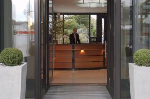 Um homem de fato está de pé na recepção. em Hotel Germania em Reutlingen
