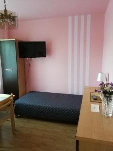 1 dormitorio con 1 cama y 1 mesa con flores en Noclegi u Mai en Olsztyn