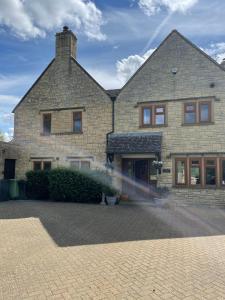 a brick house with a brick driveway in front of it at Cotswolds Luxury House in Central Bourton Large Sleeps 2-11. Pet Friendly. in Bourton on the Water