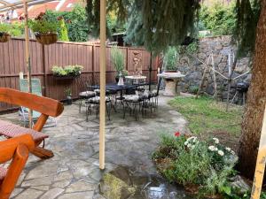 a patio with a table and chairs under an umbrella at Kisvölgy House in Eger