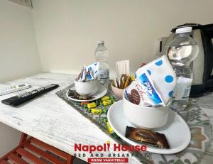 um balcão com duas chávenas de comida e um controlo remoto em B&B Napoli House em Nápoles