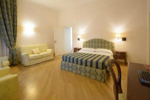 a bedroom with a bed and a couch and a chair at Domus Stella Maris - Casa per Ferie in Ancona