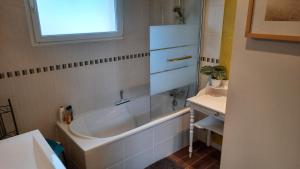 a bathroom with a bath tub and a sink at Gite galets et bois flottés proche mer gold beach meublé de tourisme 4 étoiles in Meuvaines +53 photos