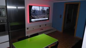 cocina con mesa verde y TV en la pared en Apartamento Climatizado Vacacional, en Vilallonga (Villalonga)