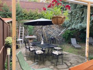 a patio with a table and chairs and an umbrella at Kisvölgy House in Eger +3 photos