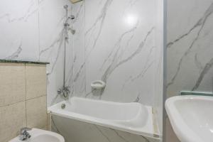 biała łazienka z białą wanną i umywalką w obiekcie skynest homes studio in JLT w Dubaju