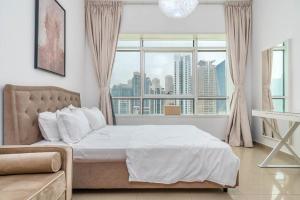 a bedroom with a bed and a large window at skynest homes studio in JLT in Dubai
