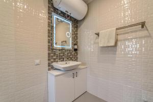 W białej łazience znajduje się umywalka i lustro. w obiekcie Mountain View Lodge w mieście Ranintsi