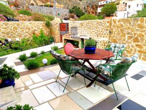 un patio con mesa, sillas y chimenea en Seaside mountain view Golden Mar villa, en Paránimfoi