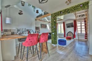 a kitchen with red stools and a table with a fireplace at ALiCe Au PaYs dEs MerVeiLLeS in Maintenon