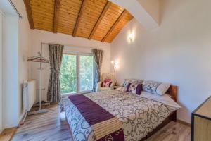 ein Schlafzimmer mit einem Bett und einem großen Fenster in der Unterkunft Mountain View Lodge in Ranintsi