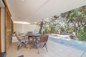 a dining room with a table and chairs on a patio at Villa Du Soleil in Vignola Mare +16 photos