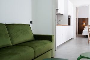 a living room with a green couch and a kitchen at Villa Costantino Luxury in Pompei +7 photos