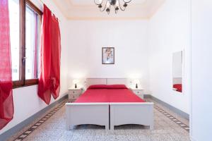 una camera da letto bianca con un letto con una coperta rossa di Guest House L'Aranceto a Firenze