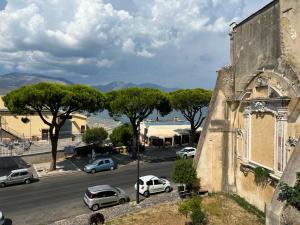 an old building with cars parked on the side of a street at Casa di Charlie in Gaeta