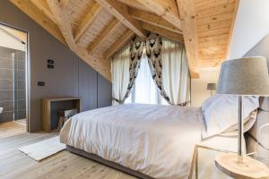 um quarto com uma cama grande e uma janela em Folgaria Top Rent em Folgaria